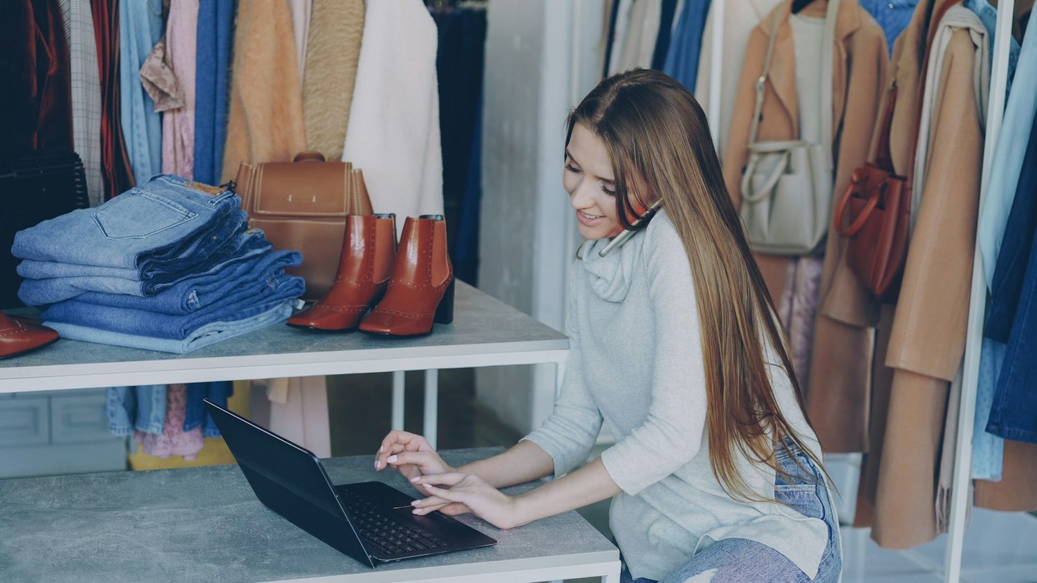 A shop owner updating their website on a laptop
