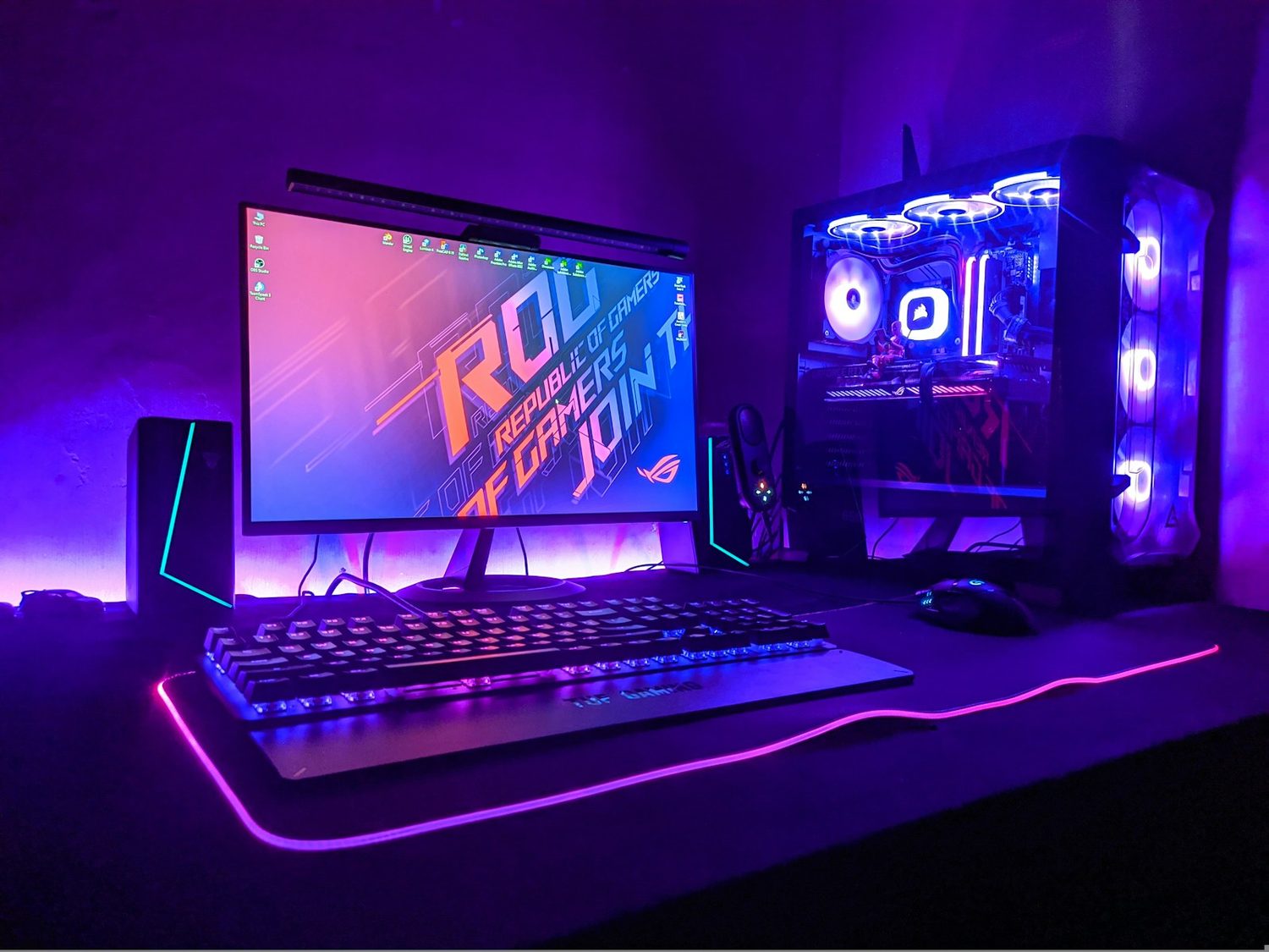 A gaming PC and monitor lit in purple