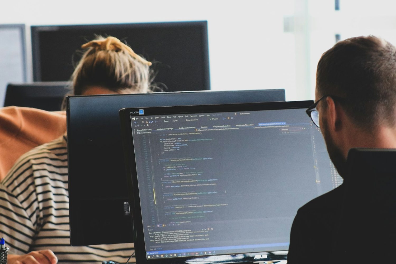 Two developers building a site at their screens